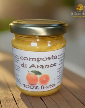 Un barattolo di composta di arance su un tavolo rustico in legno