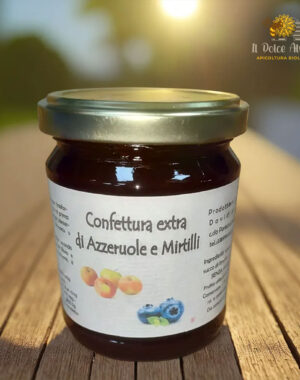 Composta di azzeruole e mirtilli in vasetto con frutti freschi.