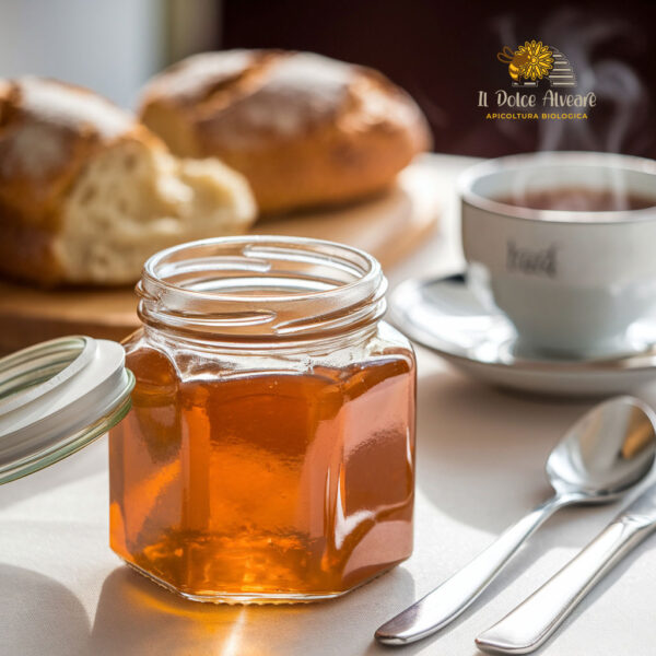 Barattolo aperto di gelatina di mele cotogne su tavola apparecchiata per la colazione, con pane e tè.