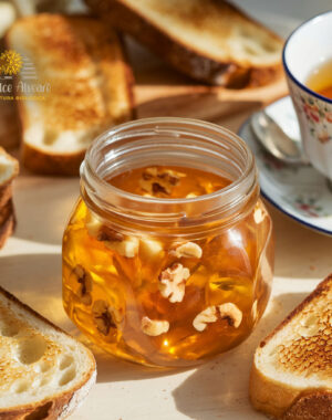 Barattolo di gelatina di mele cotogne e noci su tavola apparecchiata con pane tostato e tè.