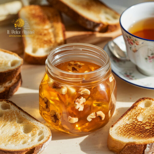 Barattolo di gelatina di mele cotogne e noci su tavola apparecchiata con pane tostato e tè.