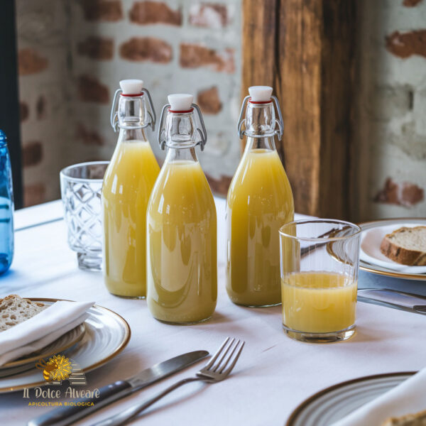 Bottiglia di succo di mele cotogne su tavola apparecchiata, con bicchiere di succo accanto.